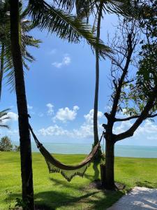 a hammock hanging between two palm trees on a beach at Spa da Alma in Coruripe