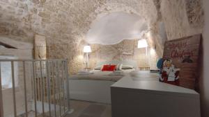 ein Schlafzimmer mit einem Bett und einer Steinwand in der Unterkunft Cà Giò in Ostuni + 28 Fotos