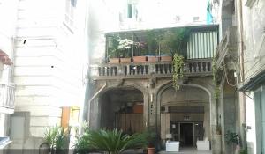 un edificio con un balcón con macetas. en O' Scartellato, en Nápoles