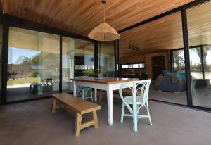 a dining room with a table and chairs at Casa Pit - Casa en chapa con pileta Barrio Privado 6PX I Hola Sur in Mar del Plata