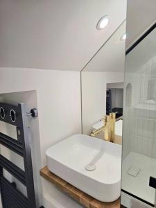 y baño con lavabo blanco y espejo. en Apartament JO2024, en Maisons-Laffitte