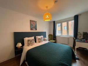 1 dormitorio con 1 cama grande con manta verde en Lady Cosmopolite, en Arras