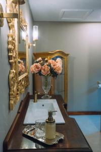 - un lavabo avec un vase de fleurs sur une table dans l'établissement The Bohemian Guesthouse, à Tzaneen