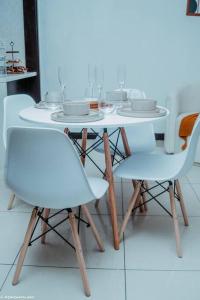 a white table and chairs with plates on it at La Casa De Made-Luxury Apartment-No loadshedding in Sandton