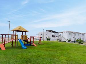 un parque infantil con un tobogán en un campo de césped en DM Hoteles Asia, en Asia
