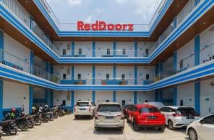 un grand bâtiment avec des voitures garées dans un parking dans l'établissement RedDoorz Plus near Palembang Icon Mall 2, à Palembang