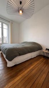 a bedroom with a large bed with a chandelier at Appartement neuf au centre d'Épernay. in Épernay