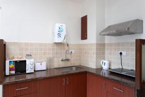 a kitchen with a sink and a microwave at 2bhk Aqua Grandiosa Near Baga beach in Arpora