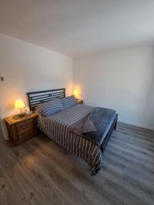 - une chambre avec un lit et une table de chevet avec une lampe dans l'établissement Superbe condo face aux pentes de ski Stoneham!!!, à Stoneham