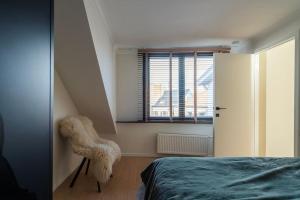 a bedroom with a bed and a window at City Centre Apartment in Kortrijk