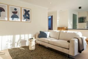 sala de estar con sofá blanco y cocina en City Centre Apartment en Kortrijk