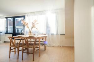 een eetkamer met een houten tafel en stoelen bij City Centre Apartment in Kortrijk