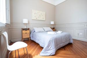 um quarto branco com uma cama e uma cadeira em Acogedor apartamento en Palermo Buenos Aires em Buenos Aires