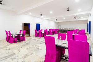 a conference room with pink chairs and a table at Desert Residency camp Jaisalmer with swimming pool in Jaisalmer