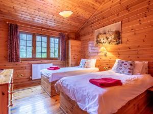 a bedroom with two beds in a log cabin at 4 Bed in Clovelly 00356 in Clovelly