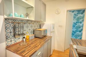 y cocina con encimera, microondas y nevera. en Modern 2BD Stylish Apartment with Balcony - Close to Saint Thomas Beach, en Marsaskala