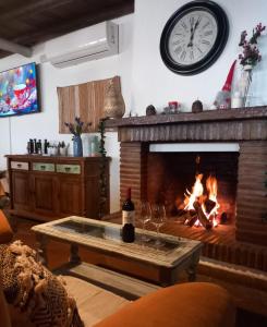 Hotel Rural Inz-Almaraz في خيميرا دي ليبار: غرفة معيشة مع موقد مع ساعة على الحائط