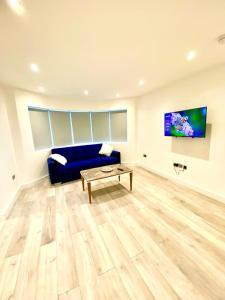 a living room with a blue couch and a table at Comfortable One Bedroom Flat with free Car Park in London in London