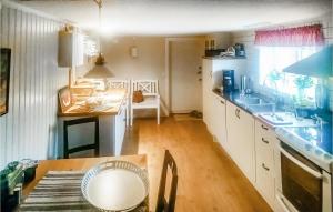 a kitchen with white cabinets and a table and a sink at 5 Bedroom Pet Friendly Home In Vallsta in Vallsta