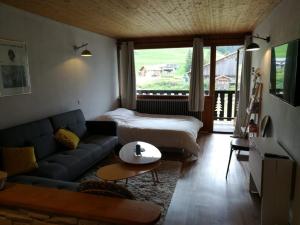 a living room with a couch and a bed at Studio Crest-Voland, 1 pièce, 4 personnes - FR-1-733-147 in Crest-Voland