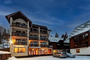 a building with a car parked in the snow at La Кrechunu in Bukovel