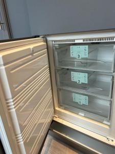 an empty refrigerator with its door open in a kitchen at Saarbrücken City Saar in Saarbrücken