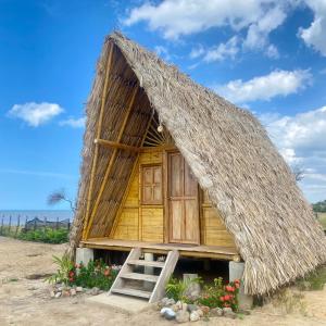 里奧阿查的住宿－OCEAN BEACH，海滩上带茅草屋顶的小小屋