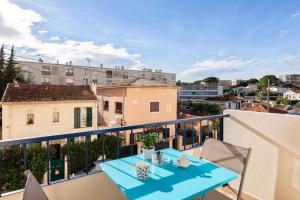 a balcony with a blue table and chairs at Private Apartment - Family - Palais des Festival - Parking - Cannes in Cannes