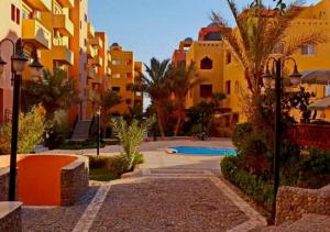 AlDora Inn Downtown Hurghada في الغردقة: ساحة مع مباني ومسبح