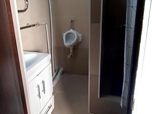 a small bathroom with a urinal and a sink at Joy in Atyrau