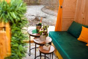 a porch with a couch and two tables with flowers at Vikendica Đoković 2 - Jahorina in Pale