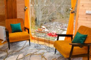 a porch with two chairs and a table and a window at Vikendica Đoković 2 - Jahorina in Pale +18 photos