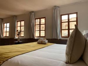 um quarto com uma grande cama branca e janelas em Katari at Plaza de Armas Cusco em Cusco