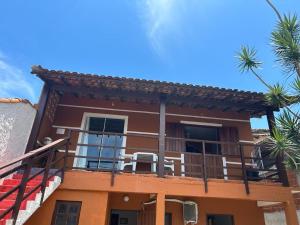 a house with a balcony with two chairs on it at Casa Eliane in Paraty