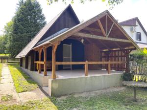 a house with a porch with a wooden roof at Nyírfa vendégház in Fadd-Dombori +10 photos