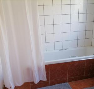 y baño con bañera y cortina de ducha. en Drakensview guesthouse en Acornhoek