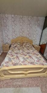 a bedroom with a bed with a wooden frame at 1 комнатная квартира в центре in Uralsk