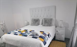 1 dormitorio con un perro blanco en la cama en Drakensview guesthouse en Acornhoek