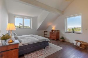 a bedroom with a bed and a dresser and two windows at Grünewaldhof in Rimbach im Odenwald in Rimbach