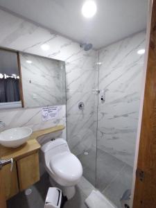 y baño con aseo, lavabo y ducha. en HOTEL A & A SANTA ALEJANDRIA, en Medellín