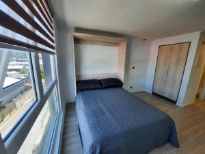 1 dormitorio con cama y ventana grande en Departamento en Valdivia., en Valdivia