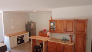 a kitchen with wooden cabinets and a refrigerator at Valdivia Tralcao Lodge 2 in Valdivia