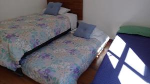 a bedroom with two beds with blue pillows at Valdivia Tralcao Lodge 2 in Valdivia
