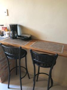a counter with two chairs and a coffee maker at Suite Compacta Wind Jeri in Jericoacoara