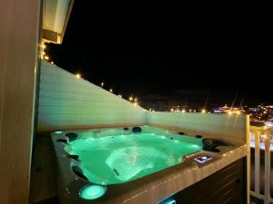 a jacuzzi tub on a balcony at night at Nord Hus Service AS, Deluxe, Sauna, Jakuzzi in Havøysund