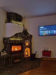 a stone fireplace in a living room with a tv at Apartament Zakopane Kościelisko in Kościelisko