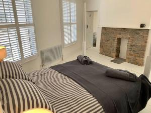 a bedroom with a large bed with a fireplace at Luxurious cottage in the heart of Falmouth in Falmouth