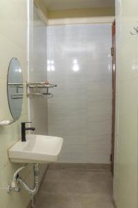 W białej łazience znajduje się umywalka i lustro. w obiekcie Hidden Treasure Lodge Chuka w mieście Chuka
