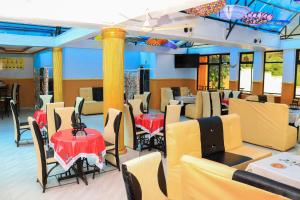 a restaurant with red and yellow tables and chairs at Hidden Treasure Lodge Chuka in Chuka