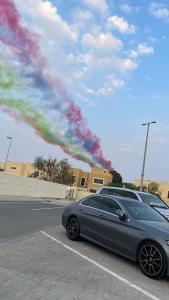 un coche aparcado en un estacionamiento con un arco iris en Nice Studio Next to AUH Airport, en Abu Dabi